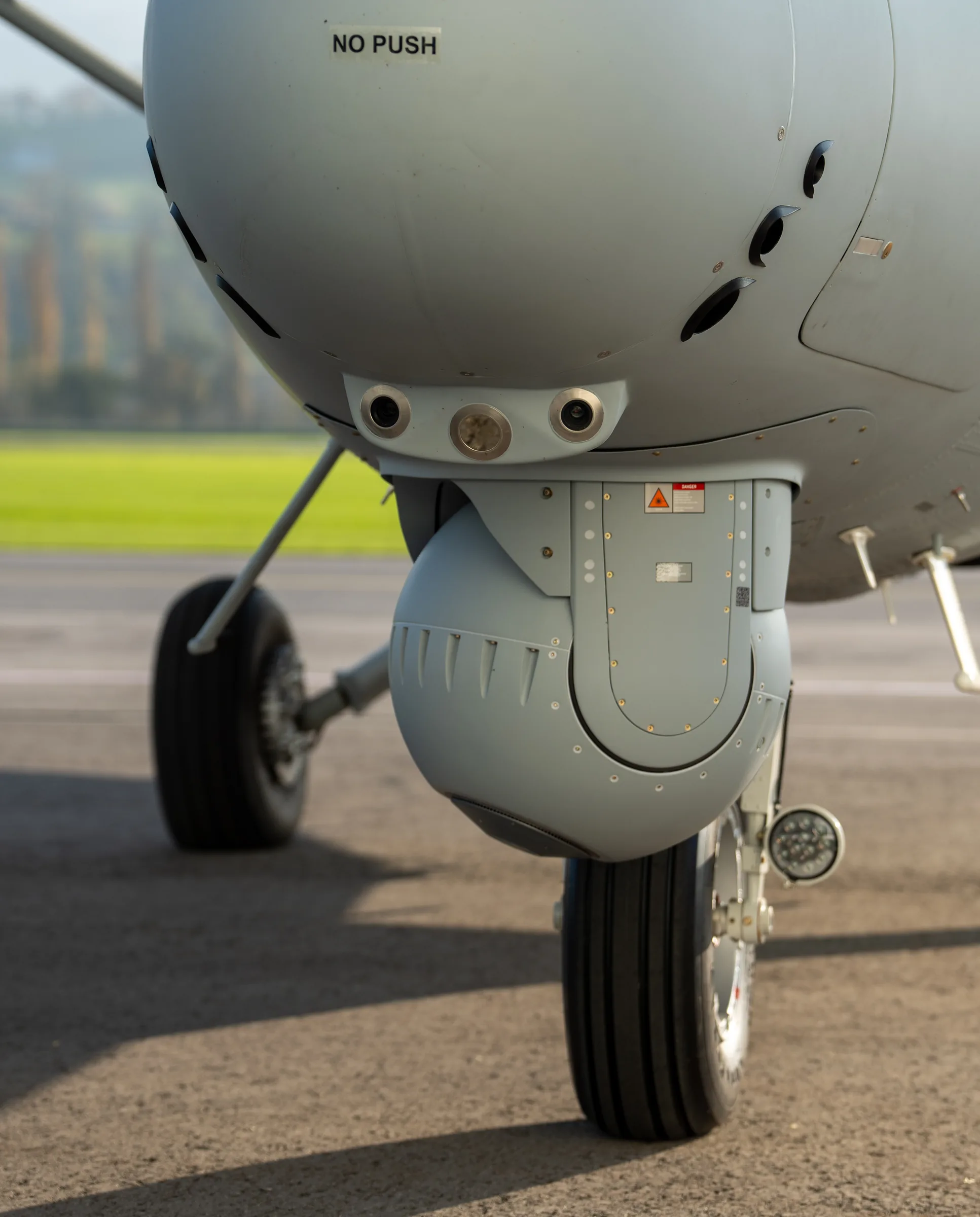 The surveillance sensor turret under the nose of a grey Danish Home Guard Twin Otter