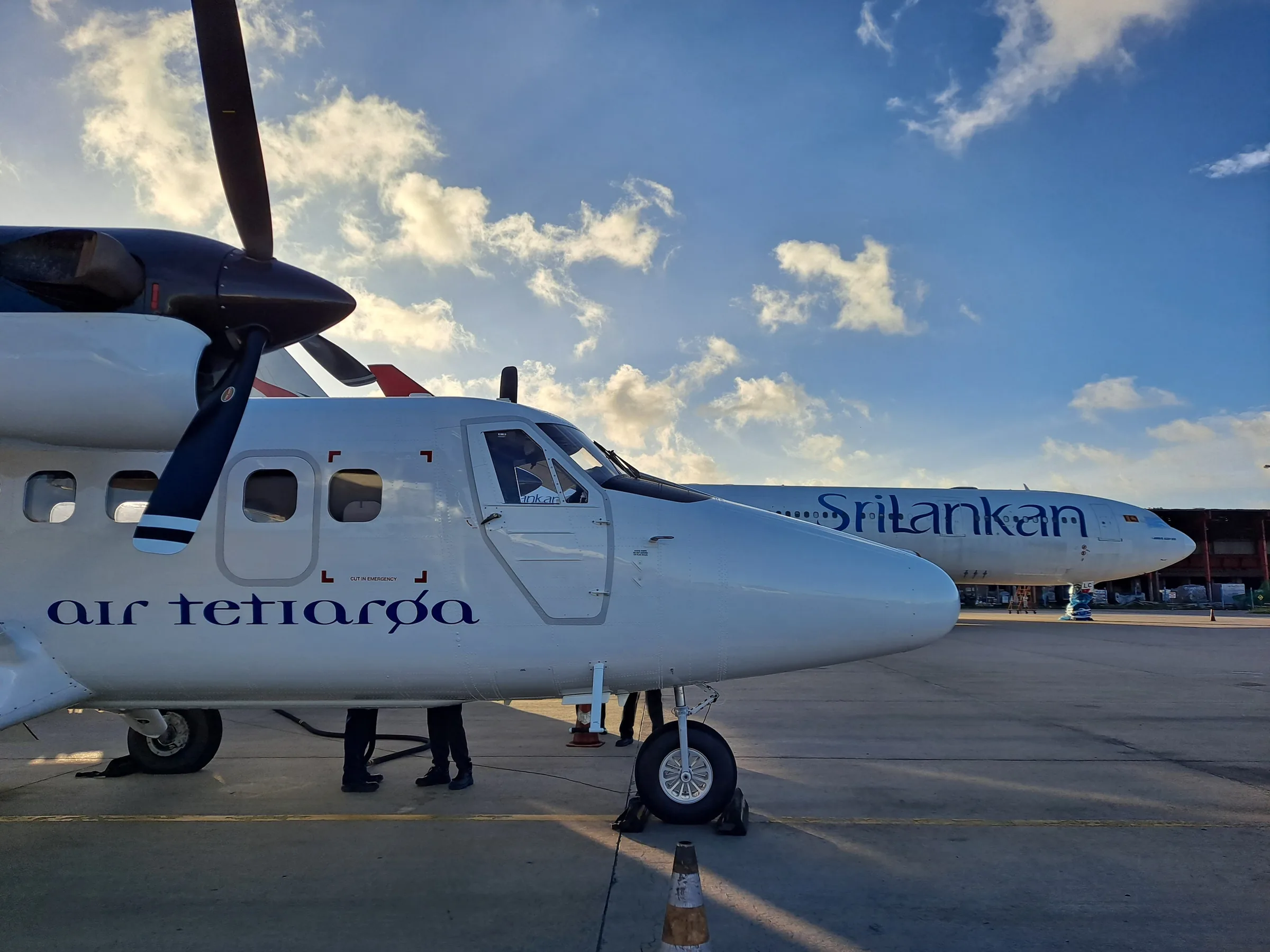The Twin Otter in Air Tetiaroa colours parked next to a SriLankan Airlines jet