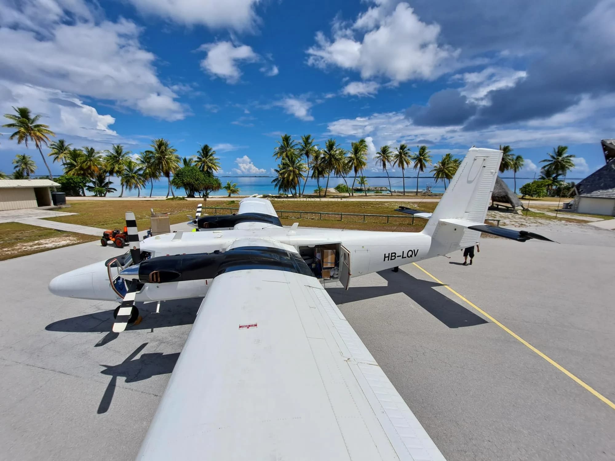 Zimex Twin Otter parked on the apron at Takaroa, French Polynesia, under palm trees