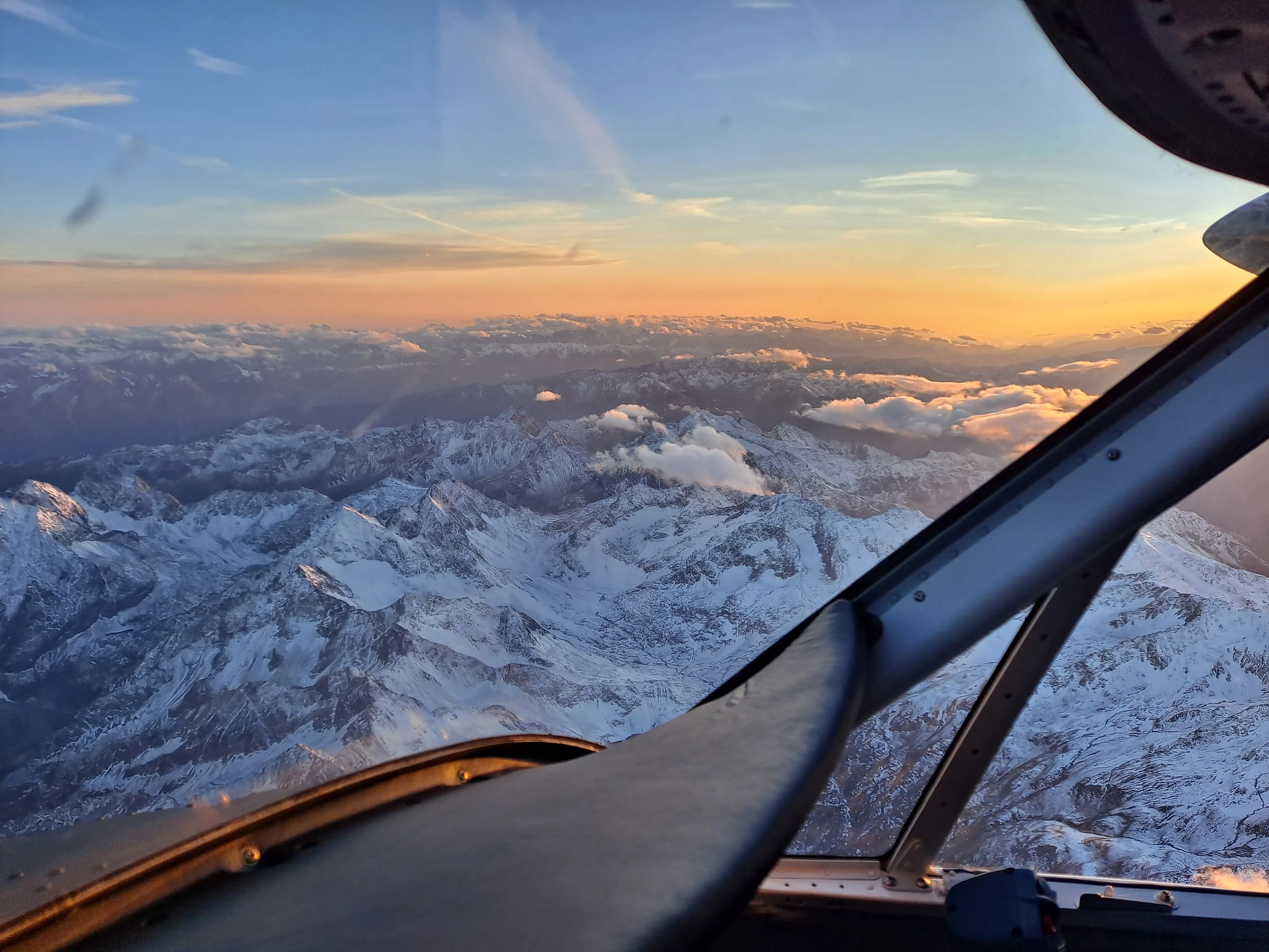 The snow-covered Alps at sunrise, seen from a Twin Otter cockpit